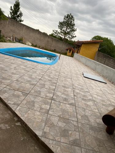 a swimming pool in the middle of a patio at Chácara Santa Fe in Ibiúna