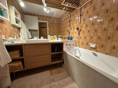 a bathroom with a tub and a sink and a bath tub at Le 104 La Reserve Courchevel, Ski aux pied in Courchevel