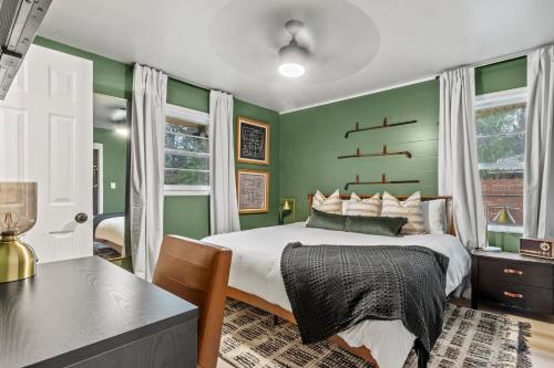 Schlafzimmer mit grünen Wänden, einem Bett und einem Schreibtisch in der Unterkunft NEW 5 Star Luxury-Masters-Hot Tub-Fire Pit-EV Char in Augusta