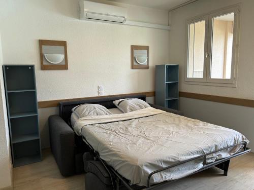 une chambre avec un lit avec deux oreillers dessus dans l'établissement Appartement vue Piscine - clim, à Saint-Raphaël