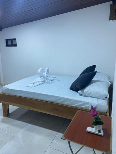 a bed with a bow on it with a table at Casa DiTi 3 in Paraíso