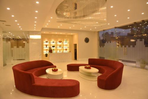 a lobby with two red chairs and a table at Grand Plaza Lords Inn Jammu in Jammu