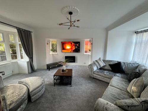 a living room with a couch and a table at Manchester City Oasis - Spacious 5 Bedroom House in Manchester