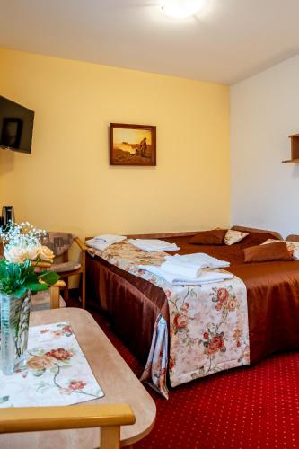 a hotel room with two beds and a table at Piastun SPA&Wellness Krynica-Zdrój in Krynica Zdrój