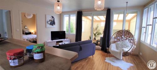 a living room with a blue couch and a chair at La maison d'Aurore et Patrice - jacuzzi couvert et jardin privés in Élincourt-Sainte-Marguerite