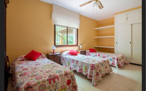 a bedroom with two beds and a window at Casa de campo con piscina junto a Sevilla in Mairena del Alcor