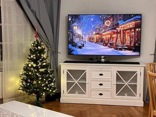 a living room with a tv and a christmas tree at At the Blue Lion & Parking Assistance in Prague