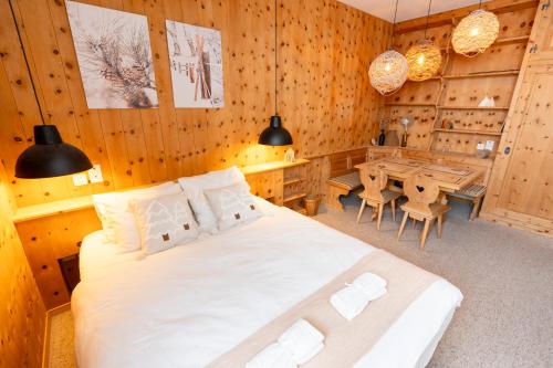 a bedroom with a large bed and a table at Berghotel Pischa Mountain Lodge in Davos