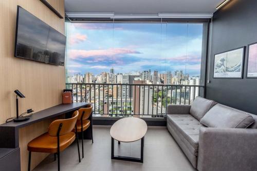 a living room with a couch and a large window at 360 VN Turiassú by Housi in Sao Paulo