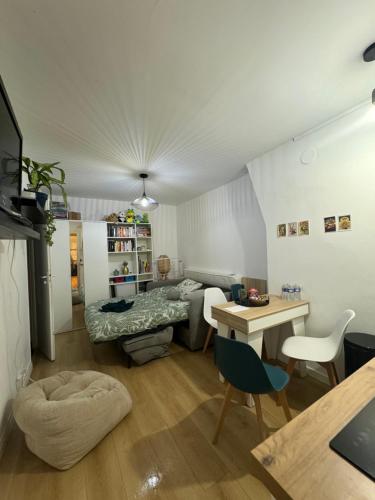 Elle comprend un petit salon avec un lit et un bureau. dans l'établissement studio paris 13, à Paris