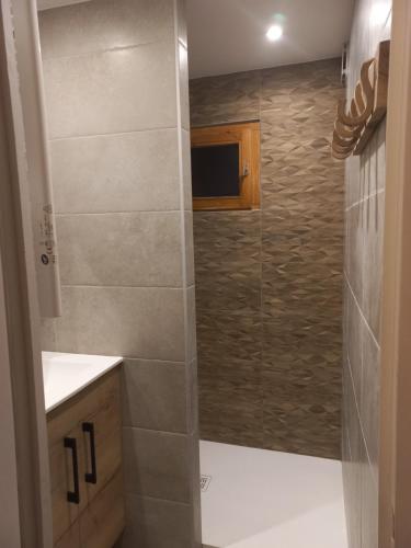 a bathroom with a shower with a glass door at Le nid douillet du Belvédère in Montvalezan