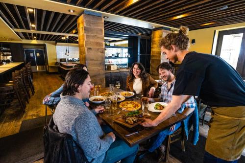 a group of people sitting around a table eating food at Hotel Terra Jackson Hole, a Noble House Resort in Teton Village