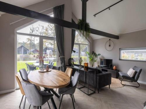 a dining room and living room with a table and chairs at Eco Villa in Latour with Garden Sauna in Oirschot
