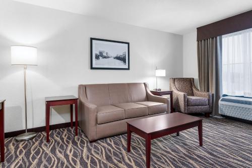 a hotel room with a couch and a chair at Cobblestone Hotel & Suites - Lynden in Lynden