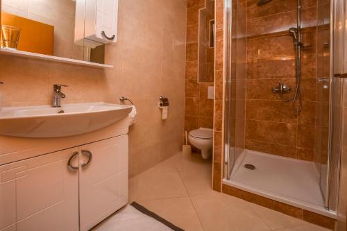 a bathroom with a sink and a shower at Apartments Perisa in Rogoznica