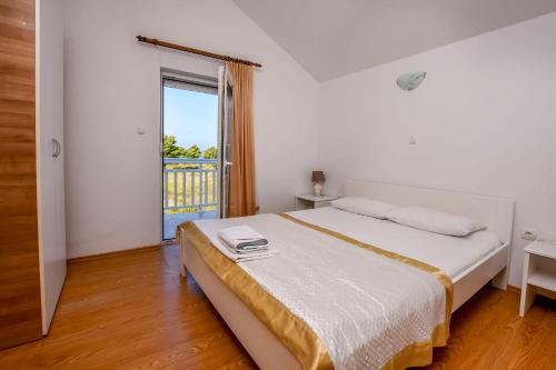 a bedroom with a bed and a large window at Apartments Perisa in Rogoznica