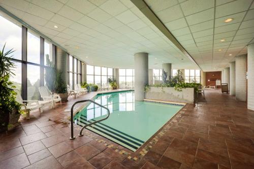a swimming pool in a large room with windows at Pool Access and Mtn Views Cozy Sugar Mtn Escape in Sugar Mountain