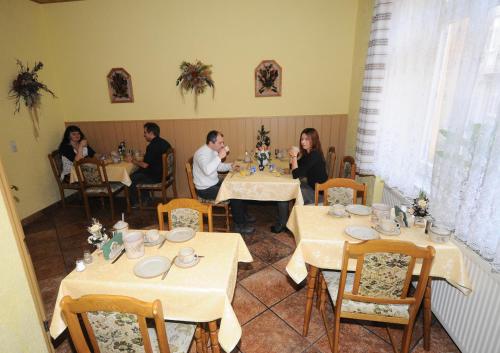a group of people sitting at tables in a restaurant at Haus Savina in Weimar