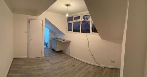 a room with a staircase with a desk and a hallway at zacknz home in Amley