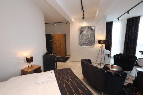 a bedroom with a bed and a living room with chairs at Golden Hill Palace in Novi Pazar