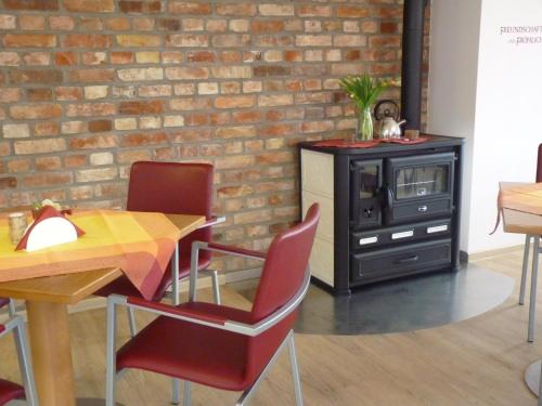 a dining room with a table and chairs and a brick wall at Cafe und Pension Blohm in Greifswald