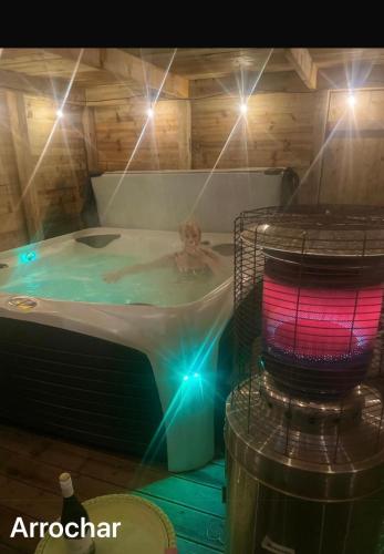 a person in a hot tub with lights at MacLeen Cottage in Arrochar