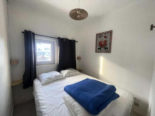 - une chambre avec un lit doté d'une couverture bleue dans l'établissement Résidence Arc En Ciel C - Coquet T2 face à la montagne et avec vue dégagée sur la 