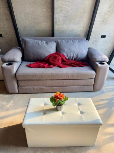 a couch with a red blanket and a flower on it at Chalet de los ciervos in Isla Cabuya
