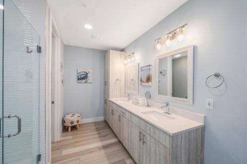 een badkamer met een wastafel en een spiegel en een douche bij Luxury Waterfront Condo, Bay Views in St Pete Beach