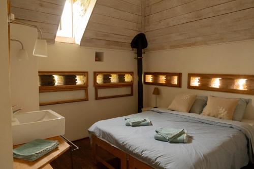 Larrazetにあるle Pigeonnier de Migouの大きなベッドと洗面台のある寝室