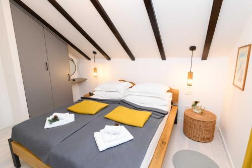 a bedroom with a bed with yellow and white pillows at Liko Diko Holiday Home in Gospić