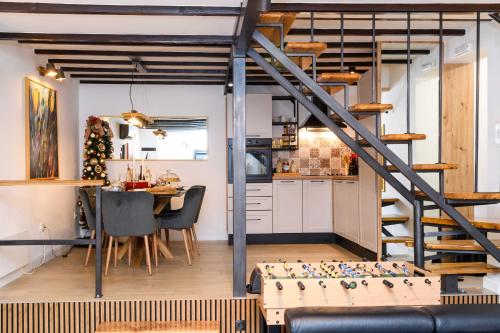 a kitchen and dining room with a spiral staircase in a loft at Liko Diko Holiday Home in Gospić