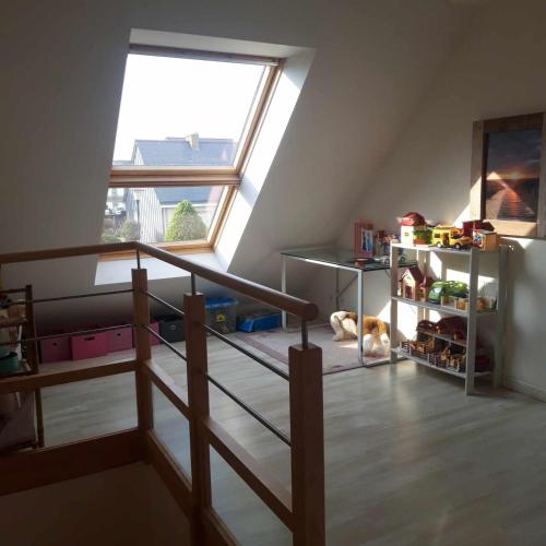 Cette chambre est dotée d'un escalier et d'une grande fenêtre. dans l'établissement Villa la Salamandre - Jullouville, à Jullouville