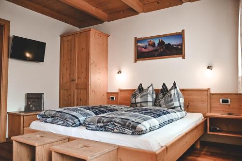 a bedroom with a wooden bed with pillows at Kerschbaumhof in San Candido