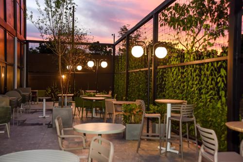a patio with tables and chairs and plants at ibis Tangará Da Serra in Tangara da Serra