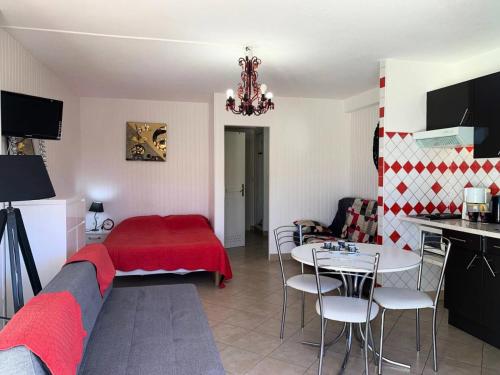 - un salon avec un lit rouge et une table dans l'établissement Résidence Héliopolis Bâtiment E - HELIOPOLIS Bâtiment E - 2 personnes rez-de -chaussée MAE-4544, au Cap d'Agde