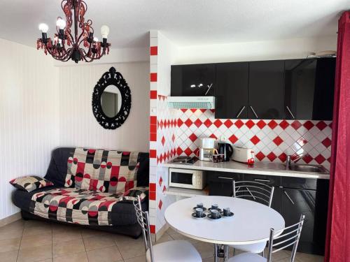 Il dispose d'une cuisine et d'un salon avec une table et un canapé. dans l'établissement Résidence Héliopolis Bâtiment E - HELIOPOLIS Bâtiment E - 2 personnes rez-de -chaussée MAE-4544, au Cap d'Agde