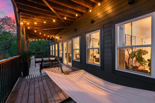 a porch with a hammock on a house at LUXE, Breathtaking Mountain Views, Hot Tub, Fire Pit, Fire Pit Table, Pool Table, 2 Living rooms, Universal EV Station in Hendersonville