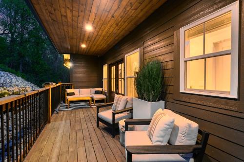 a wooden deck with chairs and a window at LUXE, Breathtaking Mountain Views, Hot Tub, Fire Pit, Fire Pit Table, Pool Table, 2 Living rooms, Universal EV Station in Hendersonville
