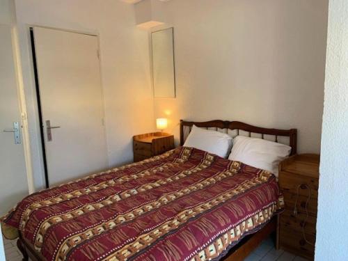 une chambre avec un lit avec une couette rouge dans l'établissement Résidence Port Nature Village 3 - Villa Duplex 6 Pers. Port Nature Village MAE-2884, au Cap d'Agde