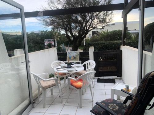 un patio avec une table et des chaises sur un balcon dans l'établissement Résidence Port Nature Colline 2 - Studio- Port Nature Colline 2 - 2 pers. MAE-6641, au Cap d'Agde
