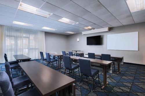 a conference room with tables and chairs and a white screen at Courtyard by Marriott San Antonio Airport in San Antonio