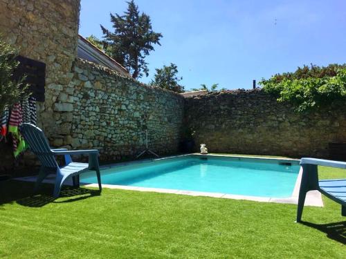 - une piscine dans une cour à côté d'un mur de briques dans l'établissement La Maison Cardau, à Névian