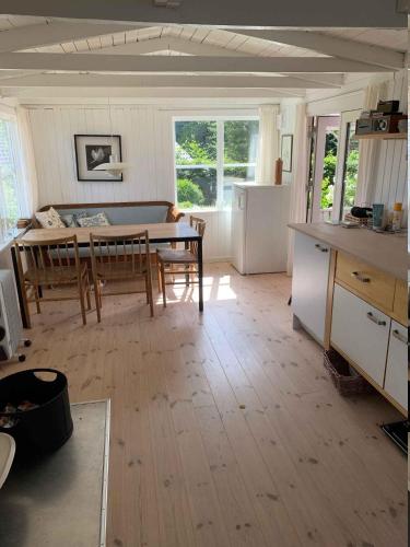 a living room with a table and a kitchen at Cozy And Modernized Fishing Cabin in Hornslet