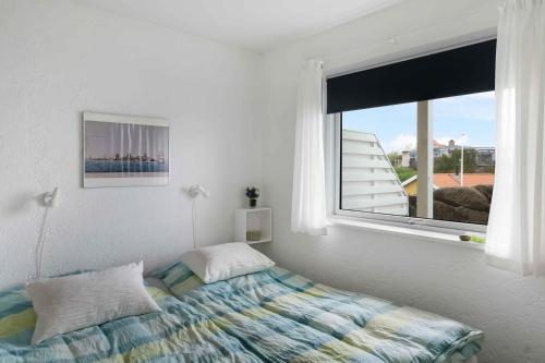 a bedroom with a bed and a large window at Holiday Apartment On The Bornholm Cliffs in Allinge