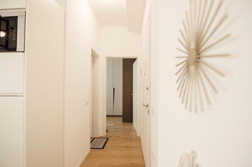 a hallway with white walls and a clock on the wall at Helia Luxury Apartment New Boulevard in Tirana