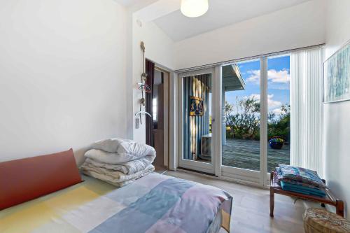 ein Schlafzimmer mit einem Bett und einem großen Fenster in der Unterkunft Cottage On Fur Island With Exceptional Sea View in Fur