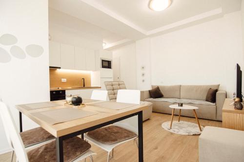 a living room with a table and a couch at Helia Luxury Apartment New Boulevard in Tirana