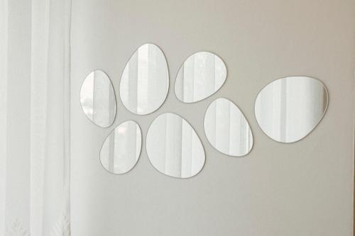 a group of mirrors hanging on a wall at Helia Luxury Apartment New Boulevard in Tirana