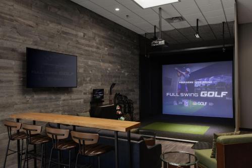 a conference room with a large screen on a brick wall at Courtyard Denver Tech Center in Greenwood Village